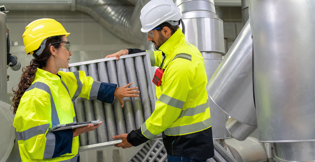 Vue en gros plan d'un filtre industriel à manches montrant la texture détaillée des fibres filtrantes avec une légère accumulation de poussière visible