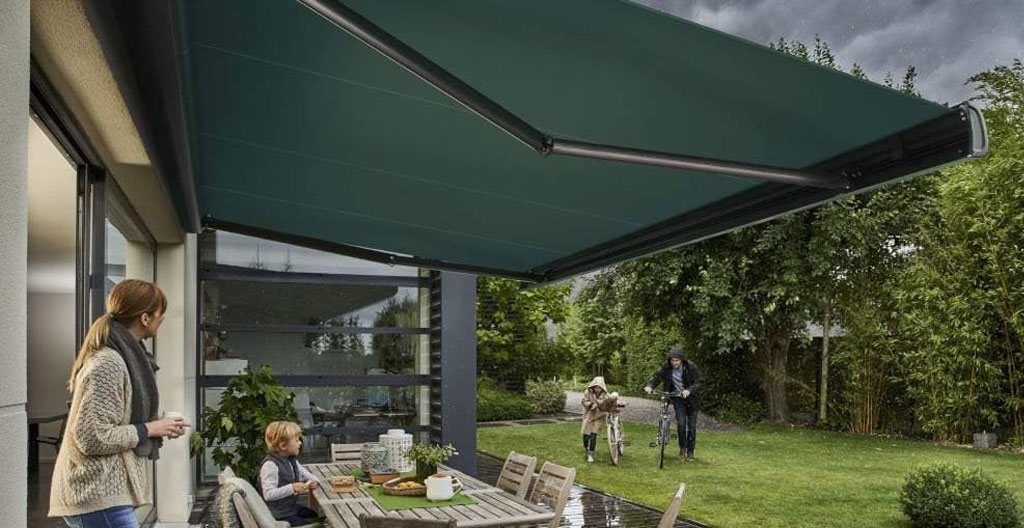 Personne vue de dos mesurant la largeur d'une terrasse avec un mètre ruban déroulé en extérieur