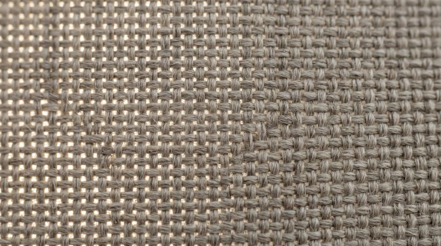 Gros plan sur la texture tissée d'une toile acrylique de protection solaire montrant la densité de trame et les fibres serrées